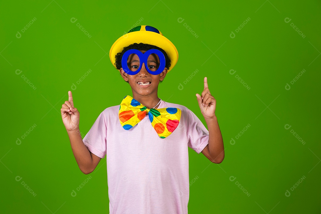 Lindo garoto fantasiado de palhaço sobre fundo verde isolado