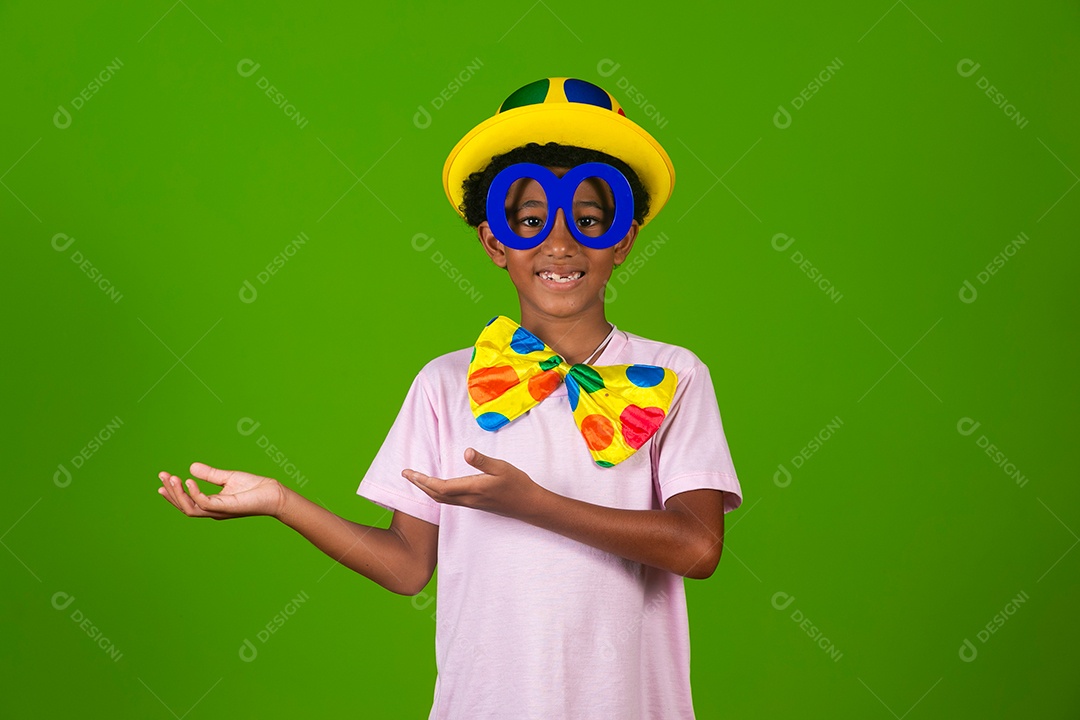 Lindo garoto fantasiado de palhaço sobre fundo verde isolado