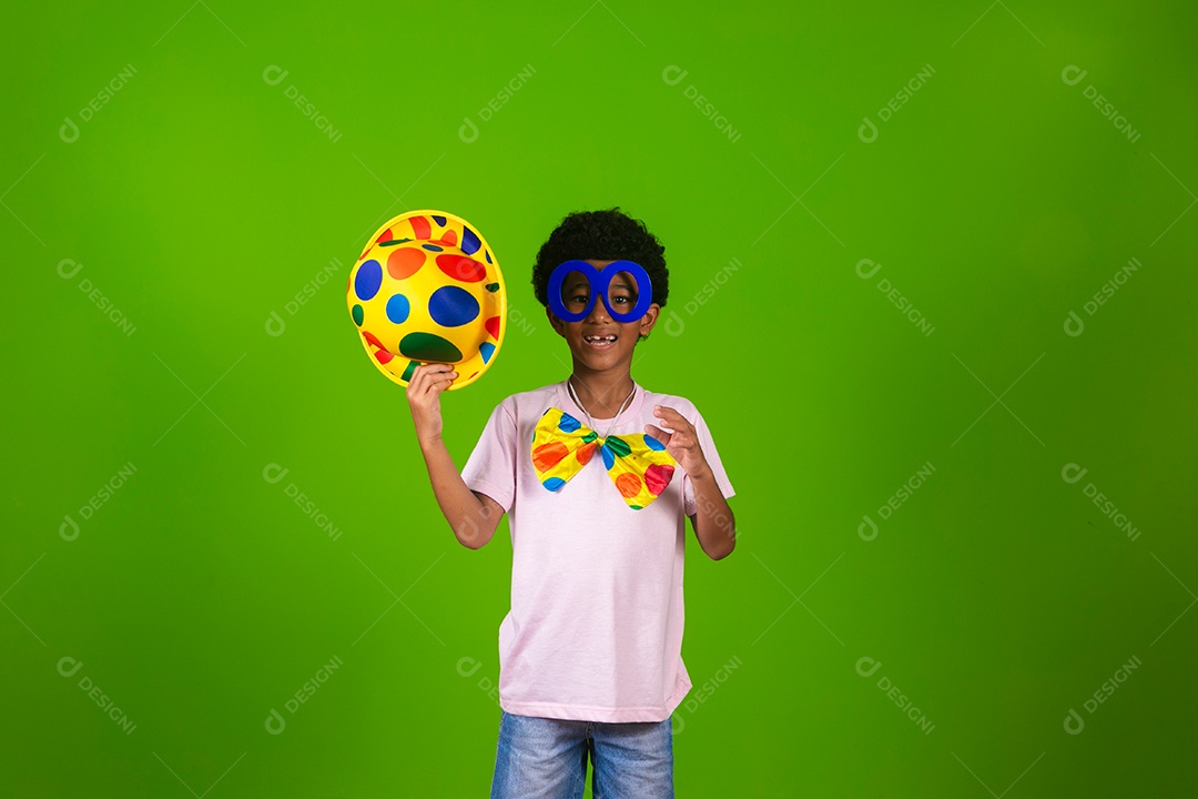Lindo garoto fantasiado de palhaço sobre fundo verde isolado