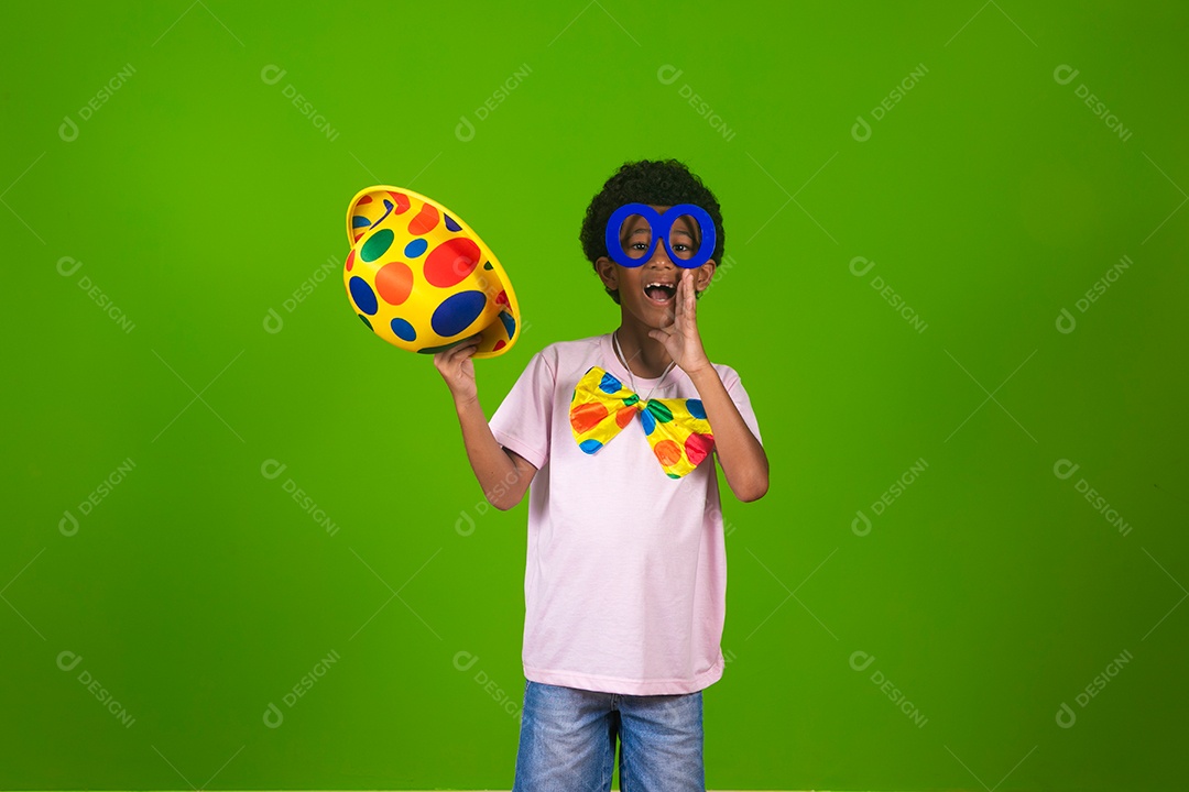 Lindo garoto fantasiado de palhaço sobre fundo verde isolado