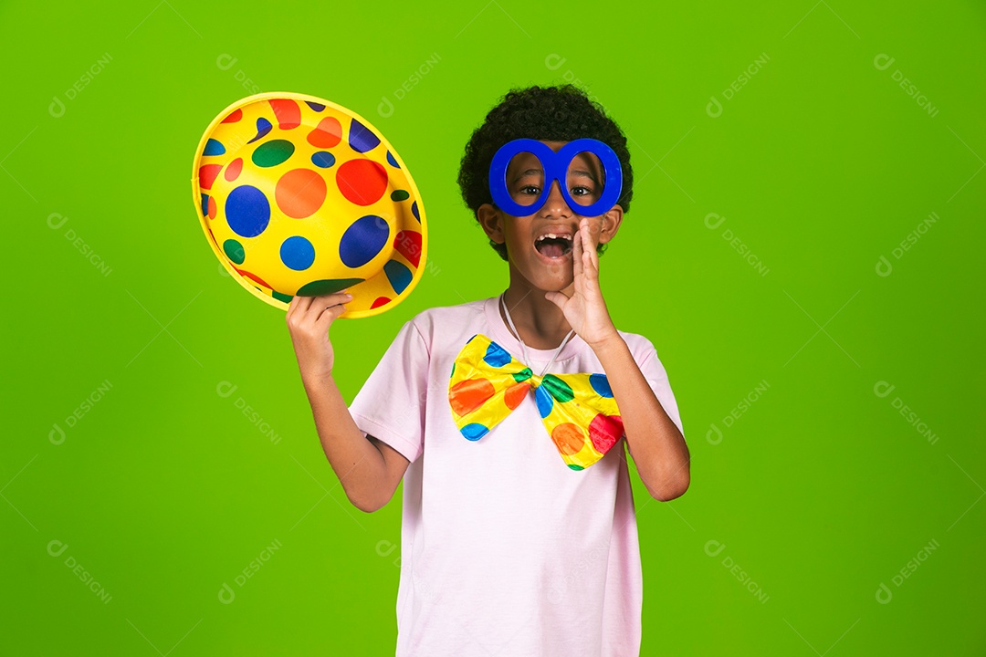 Lindo garoto fantasiado de palhaço sobre fundo verde isolado