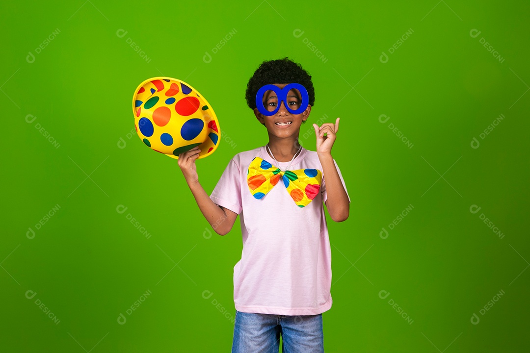 Lindo garoto fantasiado de palhaço sobre fundo verde isolado