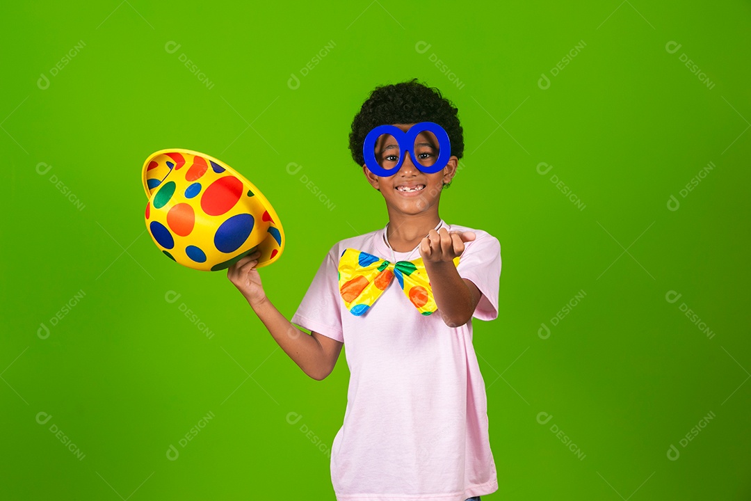 Lindo garoto fantasiado de palhaço sobre fundo verde isolado