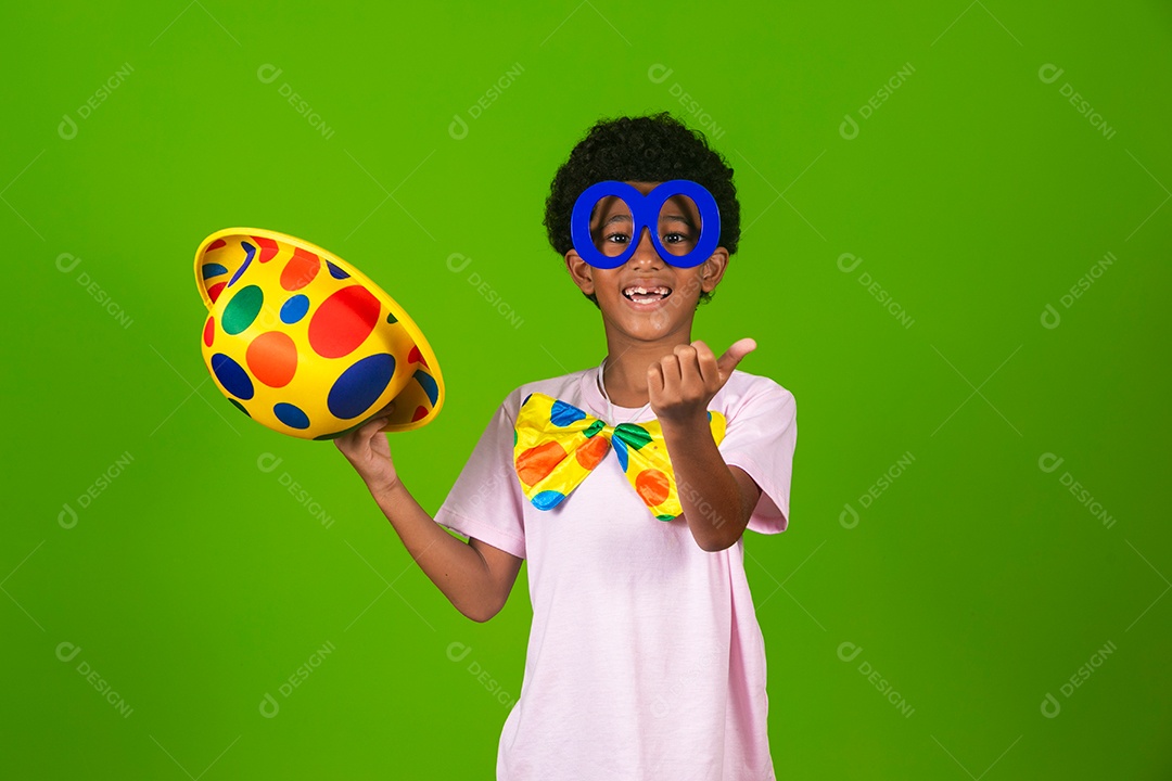 Lindo garoto fantasiado de palhaço sobre fundo verde isolado