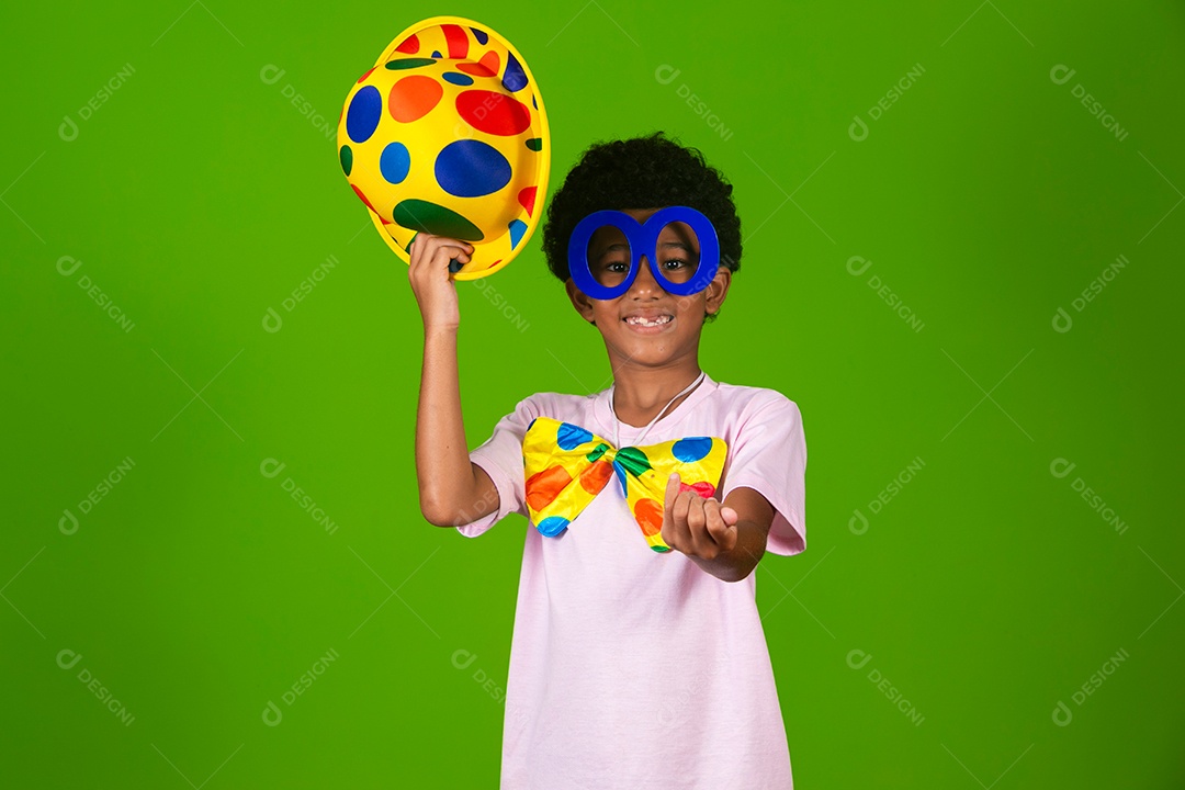 Lindo garoto fantasiado de palhaço sobre fundo verde isolado