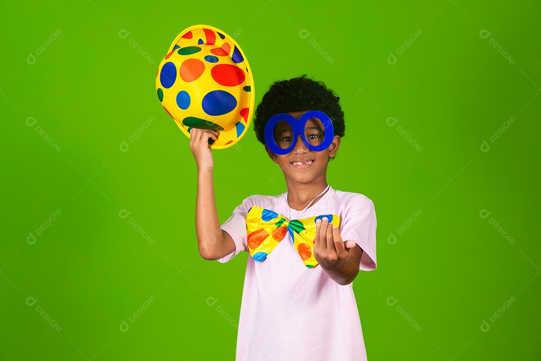 Lindo garoto fantasiado de palhaço sobre fundo verde isolado
