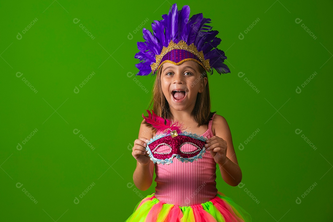 Linda garota fantasiada segurando máscara sobre fundo verde isolado