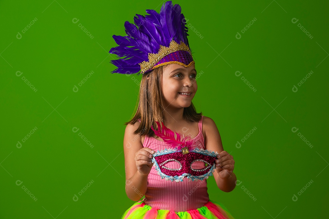 Linda garota fantasiada segurando máscara sobre fundo verde isolado