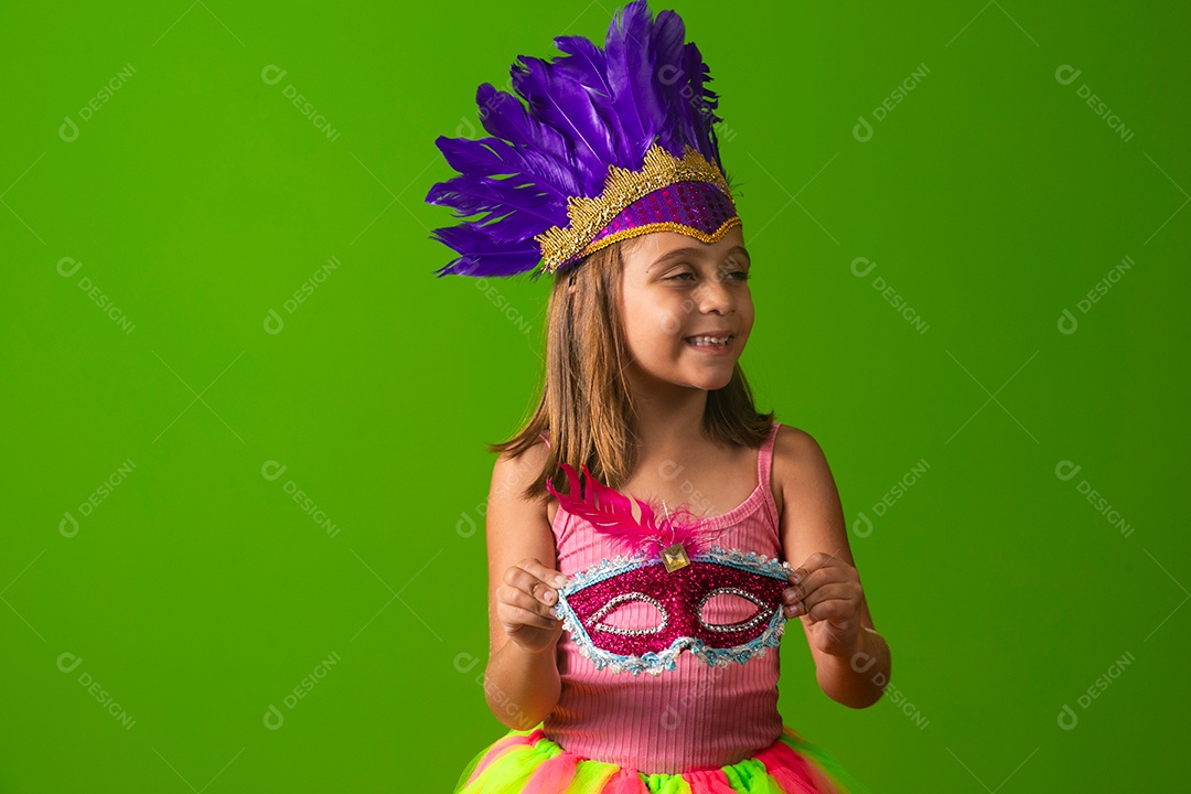 Linda garota fantasiada segurando máscara sobre fundo verde isolado