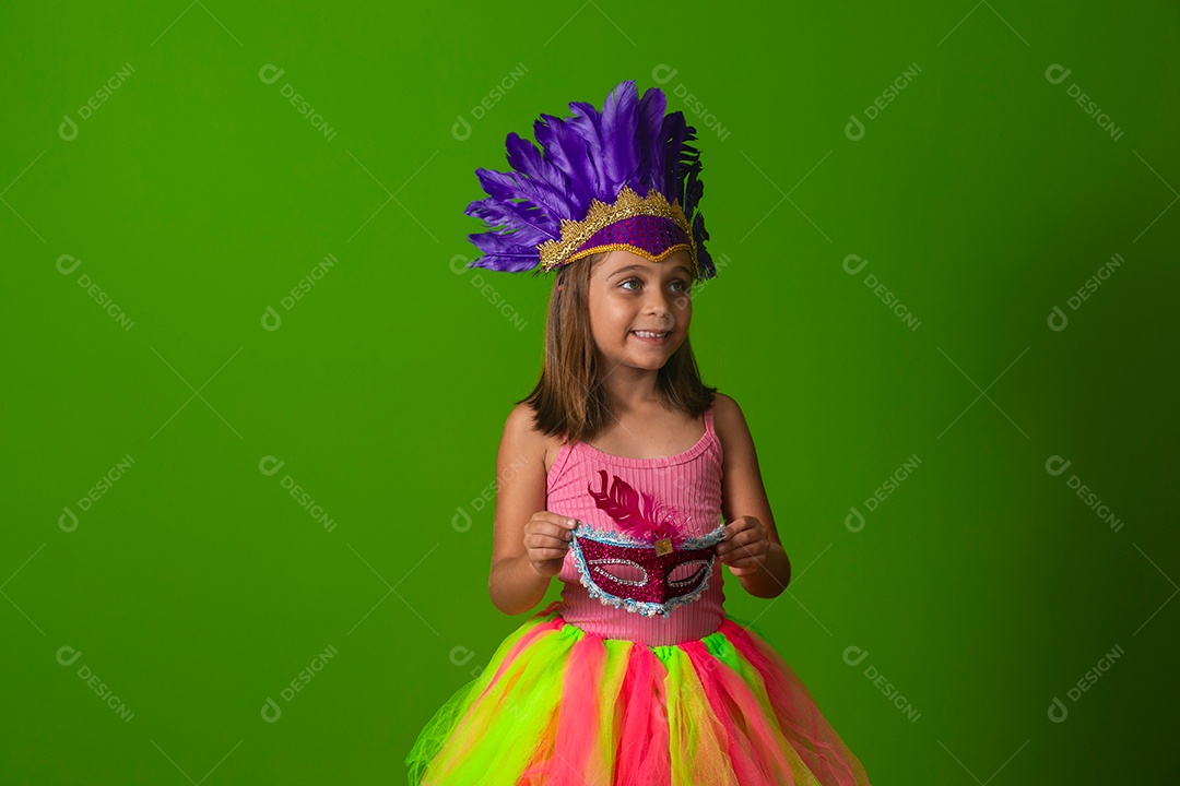 Linda garota fantasiada segurando máscara sobre fundo verde isolado