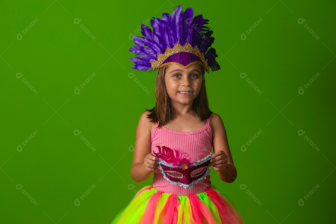Linda garota fantasiada segurando máscara sobre fundo verde isolado