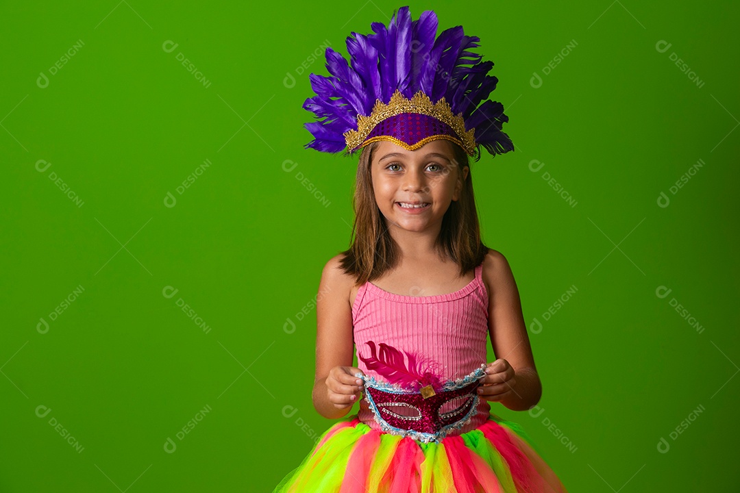 Linda garota fantasiada segurando máscara sobre fundo verde isolado