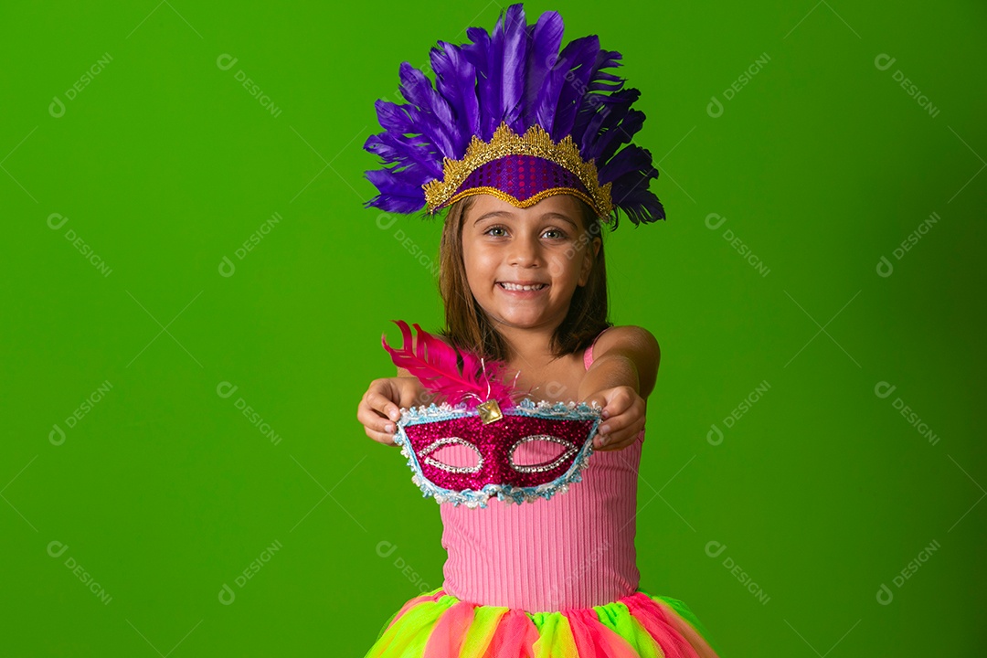 Linda garota fantasiada segurando máscara sobre fundo verde isolado