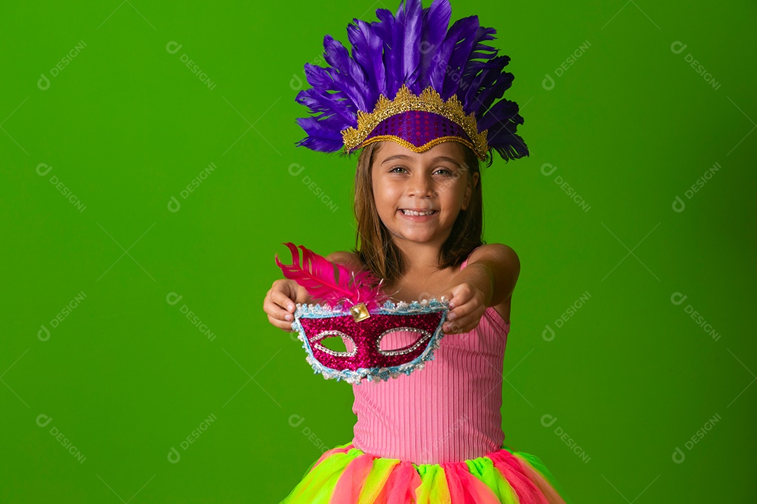 Linda garota fantasiada segurando máscara sobre fundo verde isolado