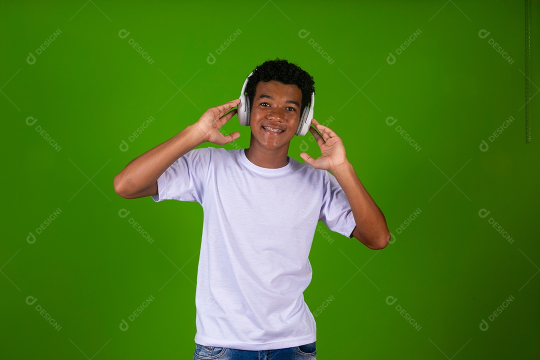Lindo garoto negro usando fone de ouvido sobre fundo verde isolado