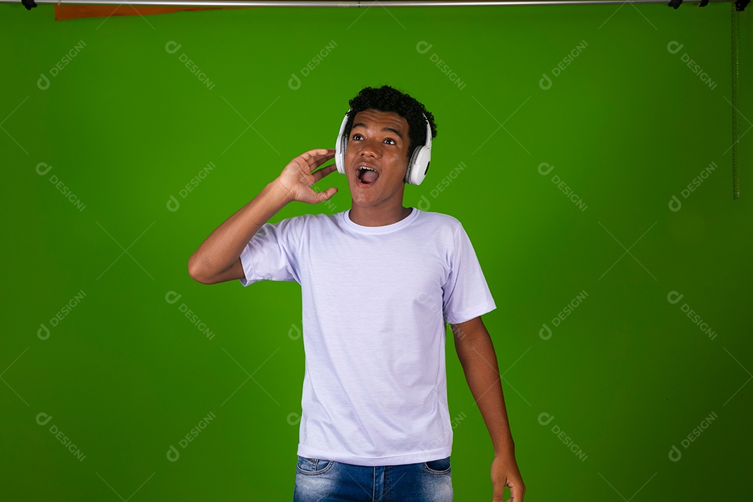 Lindo garoto negro usando fone de ouvido sobre fundo verde isolado