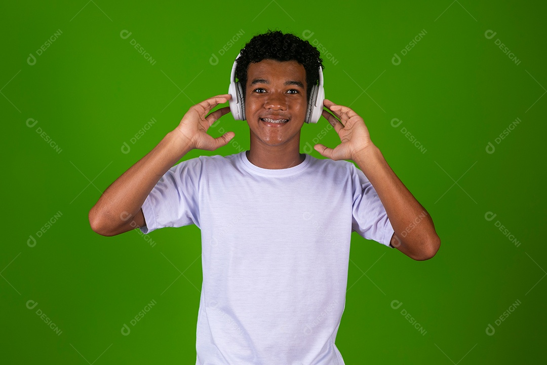 Lindo garoto negro usando fone de ouvido sobre fundo verde isolado