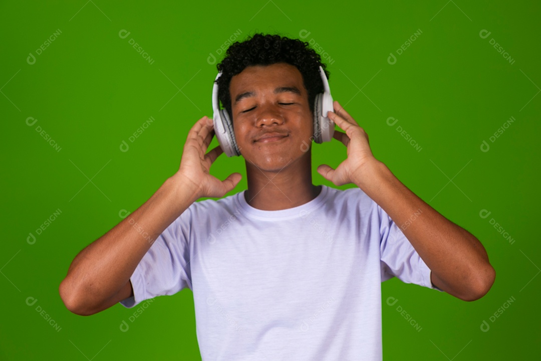 Lindo garoto negro usando fone de ouvido sobre fundo verde isolado