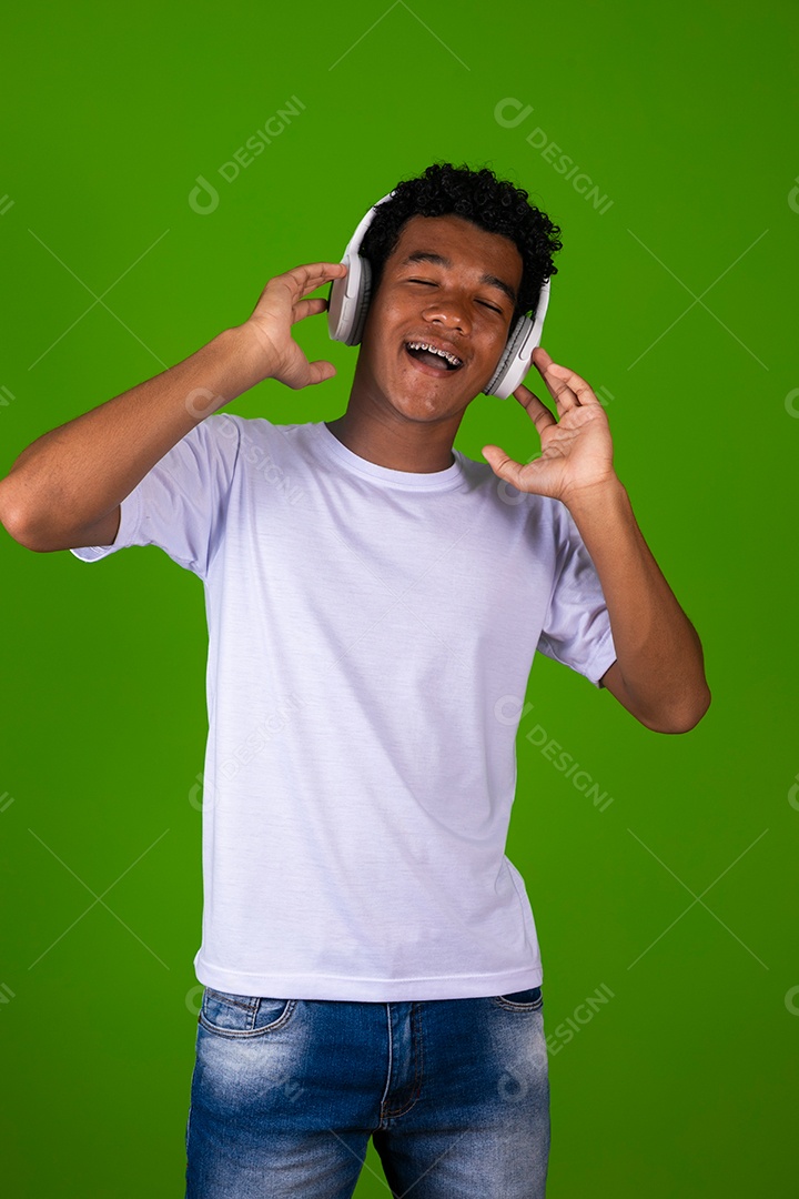 Lindo garoto negro usando fone de ouvido sobre fundo verde isolado