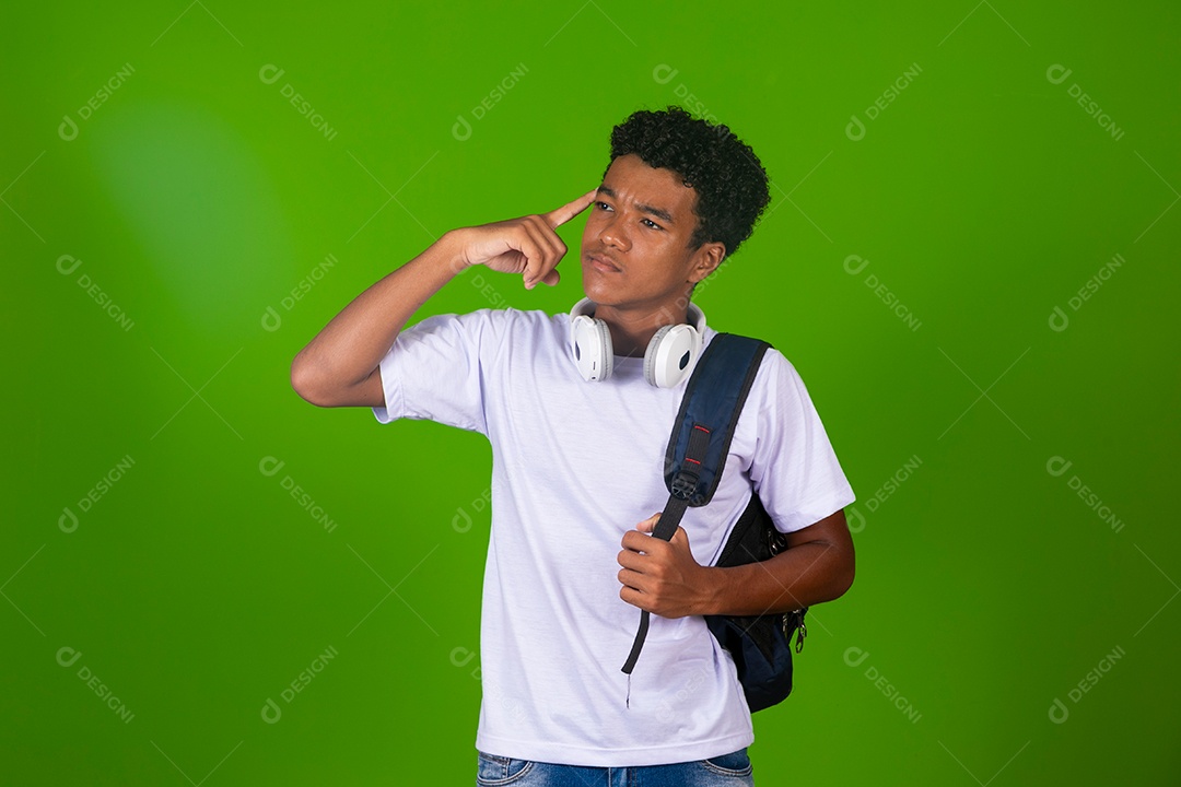 Lindo garoto negro usando fone de ouvido e mochila sobre fundo verde isolado