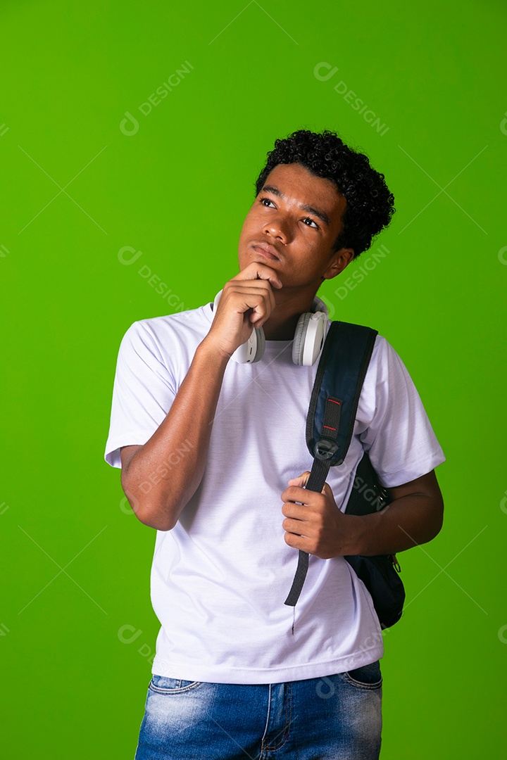 Lindo garoto negro usando fone de ouvido e mochila sobre fundo verde isolado