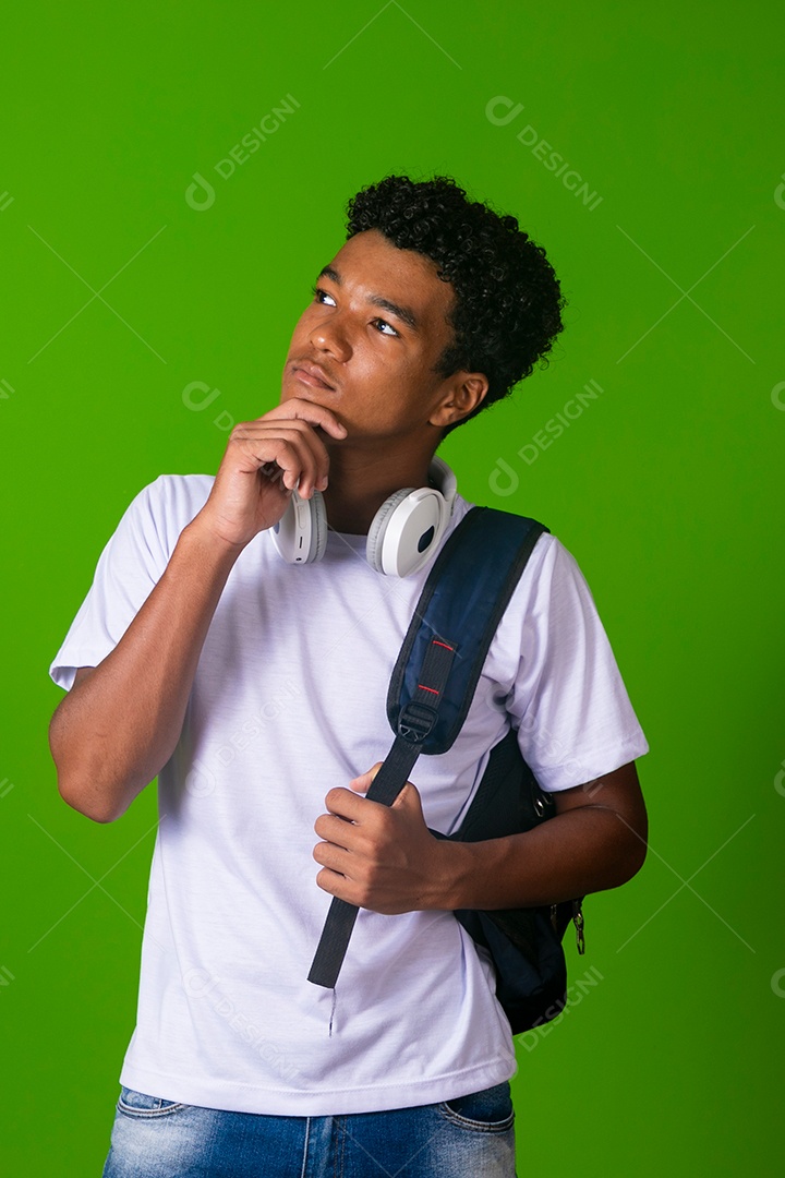 Lindo garoto negro usando fone de ouvido e mochila sobre fundo verde isolado