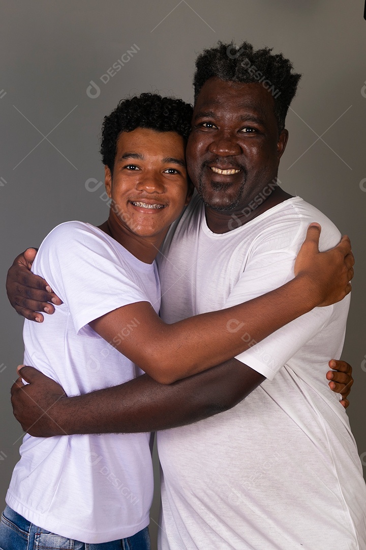 Lindo pai e filho se abraçando sorridentes sobre fundo isolado