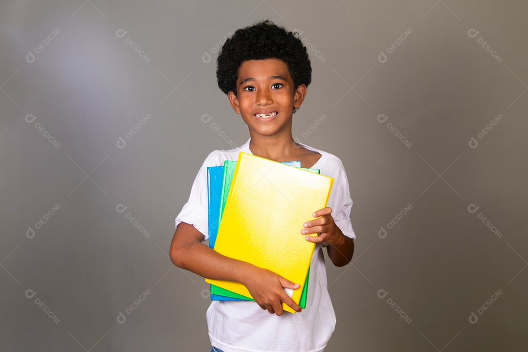 Lindo garoto negro sorridente segurando cadernos sobre fundo isolado