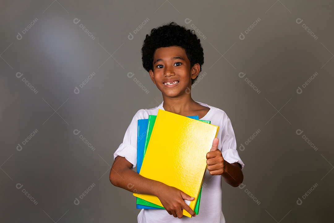 Lindo garoto negro sorridente segurando cadernos sobre fundo isolado