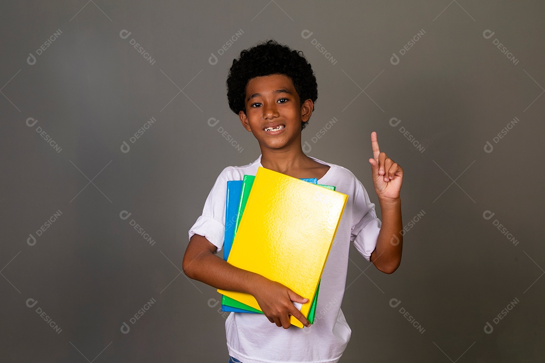 Lindo garoto negro sorridente segurando cadernos sobre fundo isolado