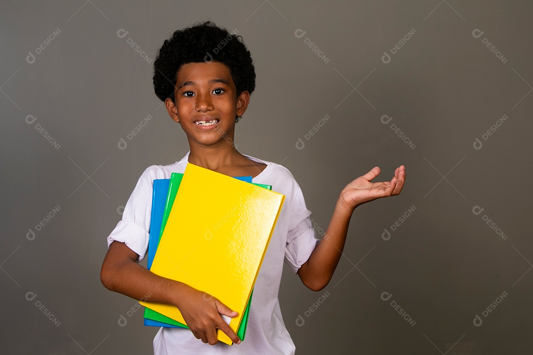 Lindo garoto negro sorridente segurando cadernos sobre fundo isolado