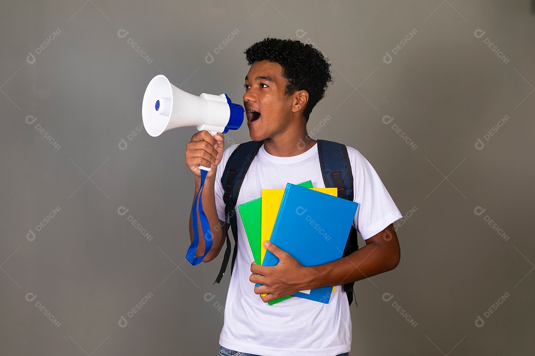 Lindo garoto negro usando bolsa e segurando cadernos e um alto falante sobre fundo isolado