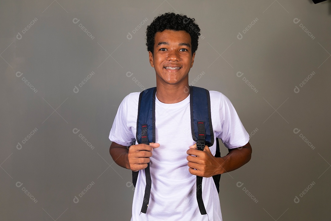 Lindo garoto negro sorridente usando bolsa sobre fundo isolado