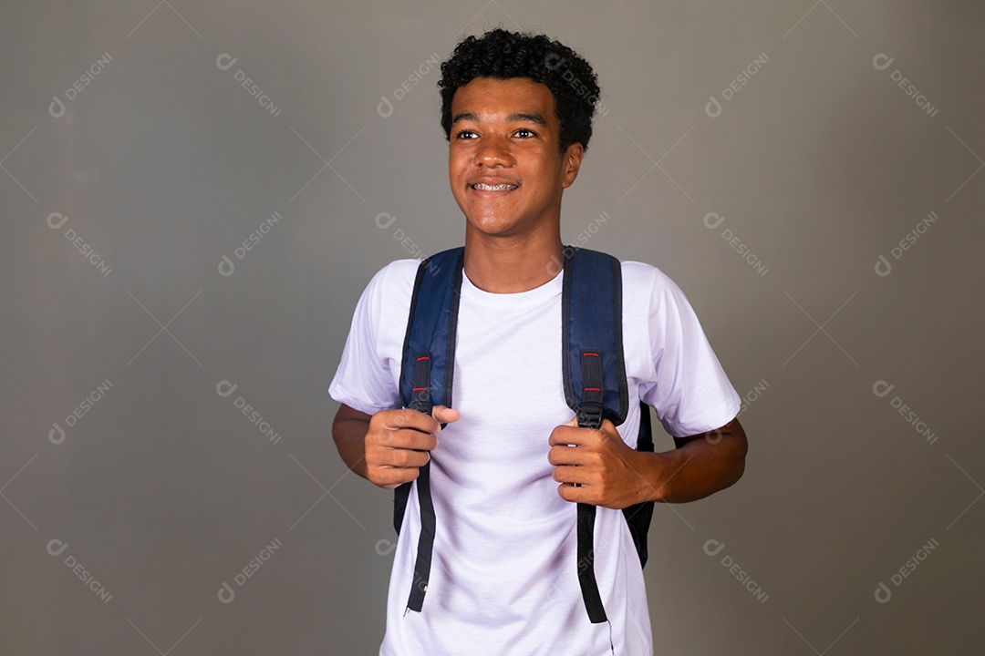 Lindo garoto negro sorridente usando bolsa sobre fundo isolado