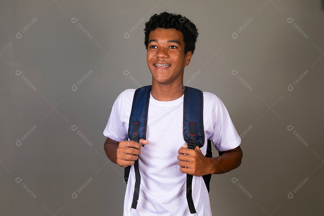 Lindo garoto negro sorridente usando bolsa sobre fundo isolado