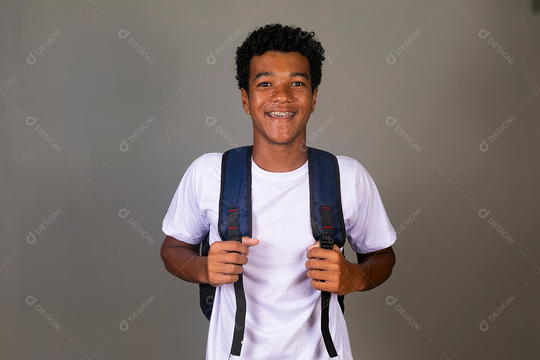 Lindo garoto negro sorridente usando bolsa sobre fundo isolado