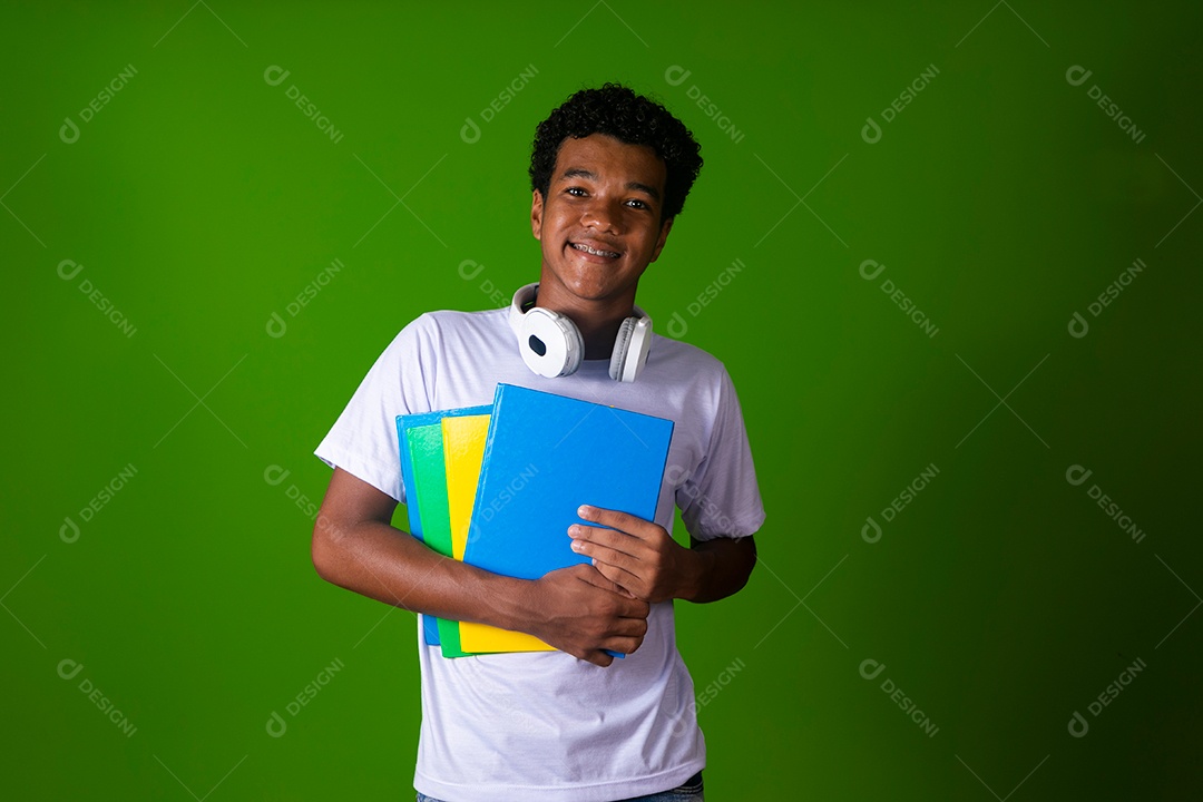 Lindo garoto negro usando bolsa e fone de ouvido segurando caderno sobre fundo isolado