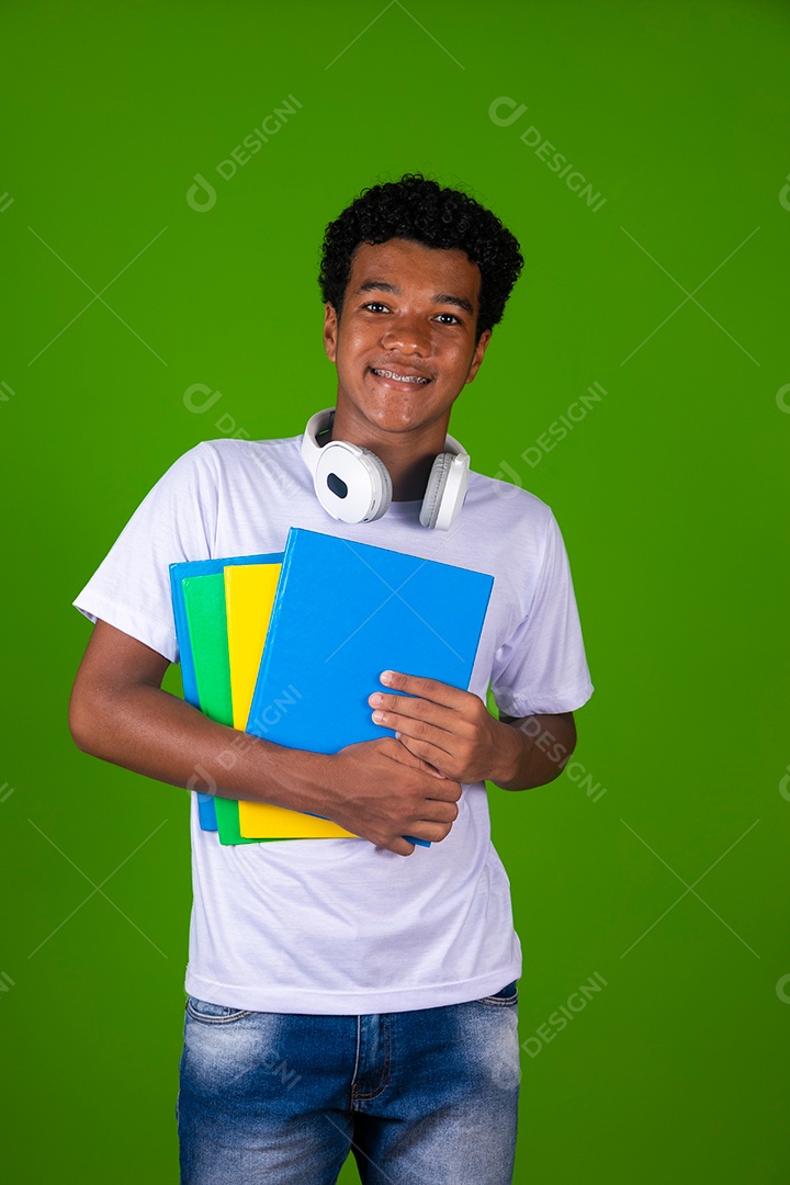 Lindo garoto negro usando bolsa e fone de ouvido segurando caderno sobre fundo isolado