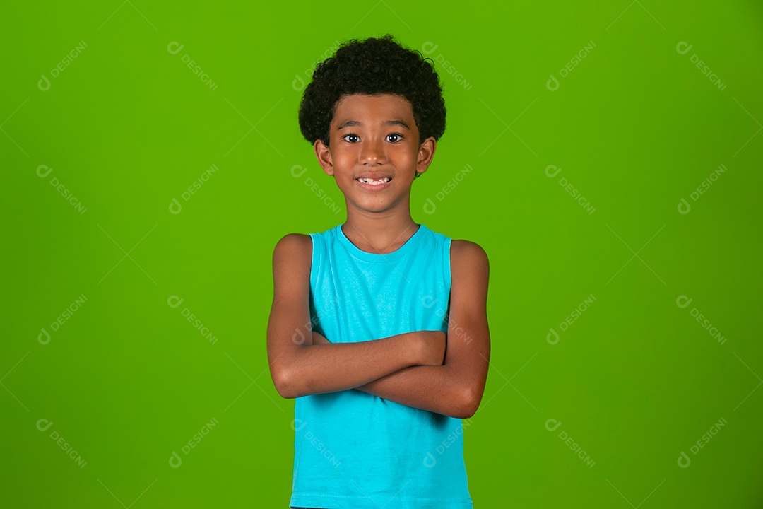 Lindo garoto negro sorridente de camisa azul sobre fundo verde isolado