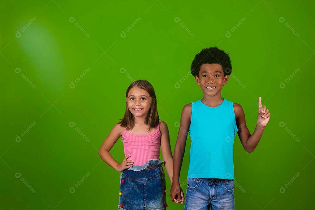 Lindas crianças sorridentes de mãos dadas sobre fundo verde isolado