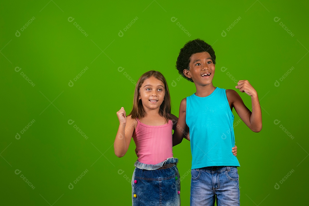 Lindas crianças sorridentes abraçados sobre fundo verde isolado