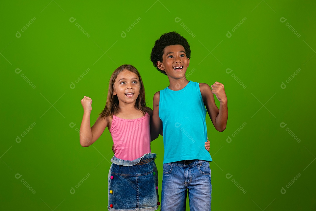 Lindas crianças sorridentes abraçados sobre fundo verde isolado