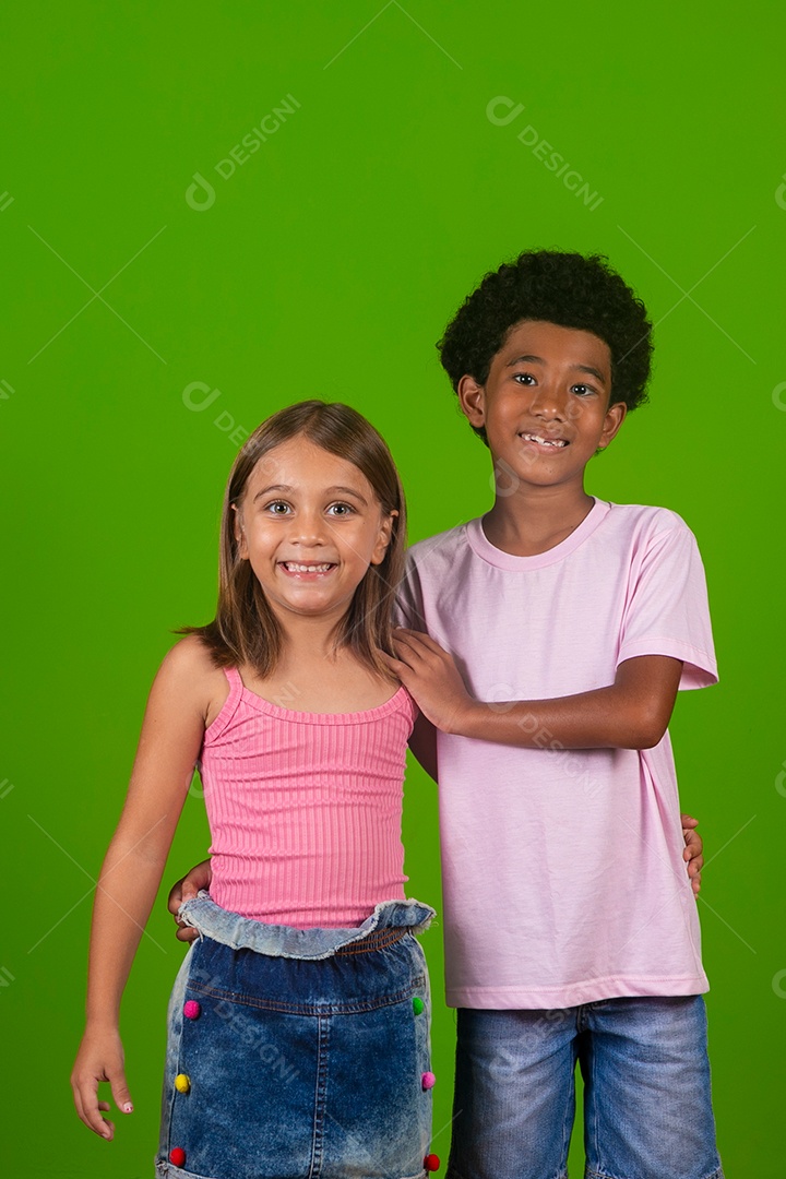Lindas crianças sorridentes abraçados sobre fundo verde isolado