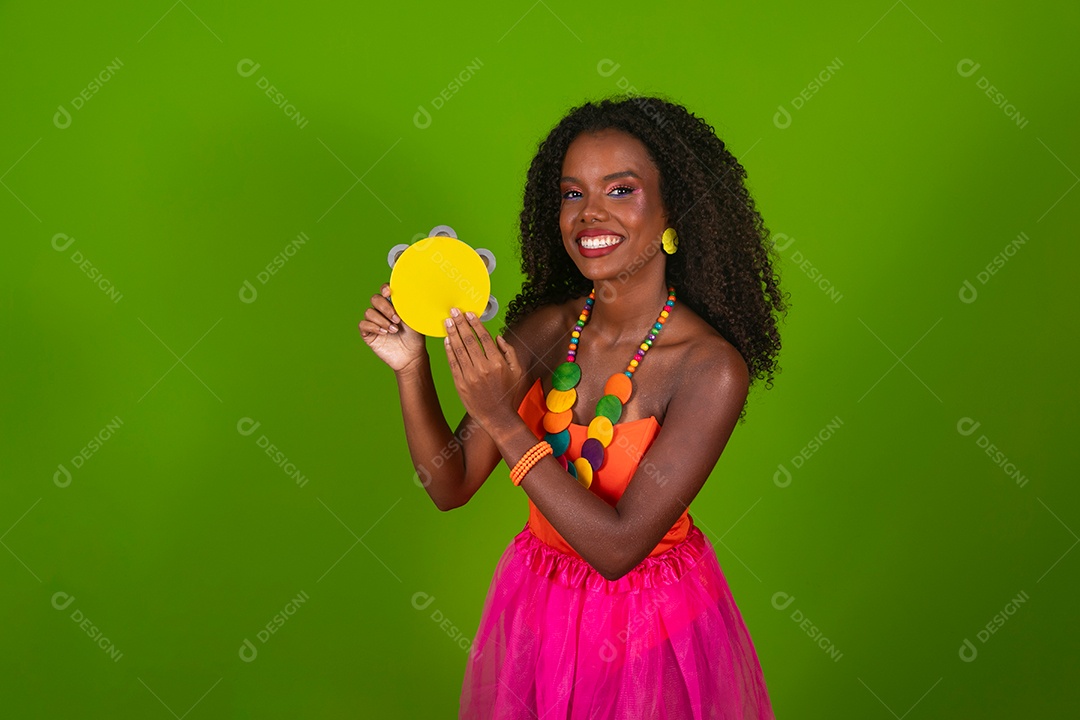 Linda morena fantasiada sorridente segurando pandeiro sobre fundo verde isolado