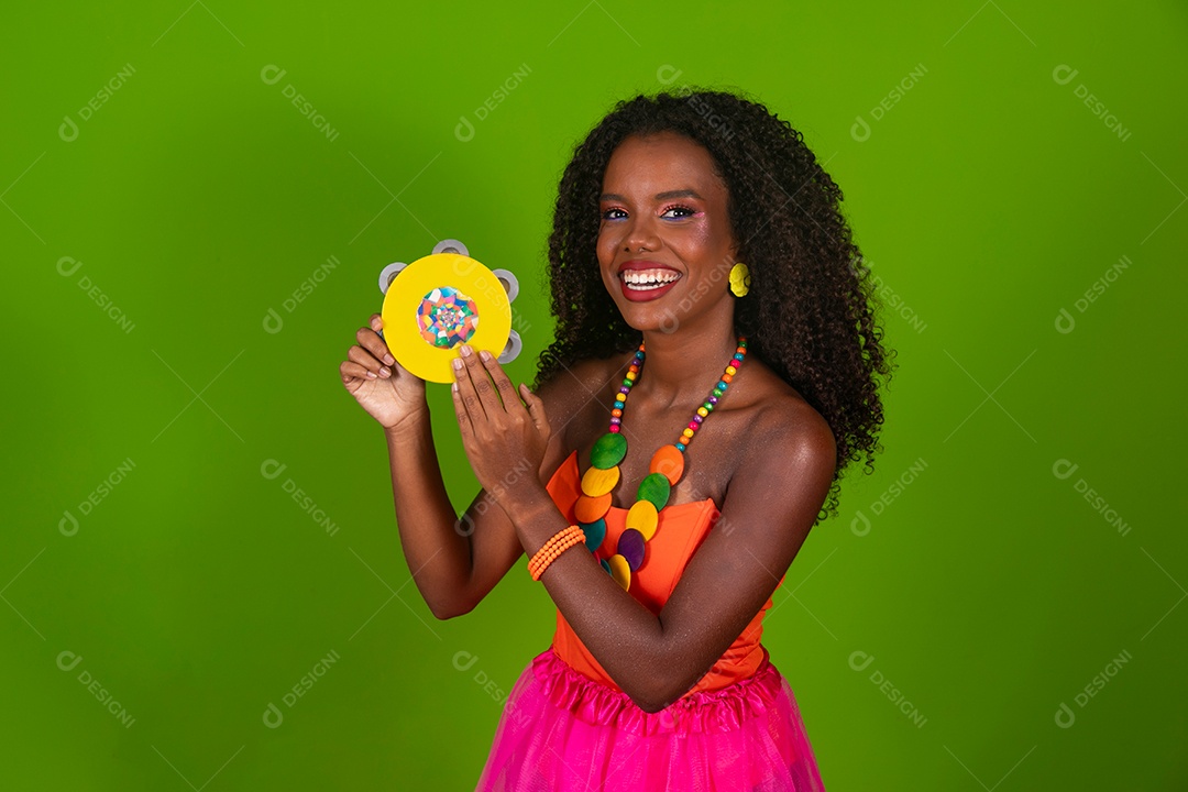 Linda morena fantasiada sorridente segurando pandeiro sobre fundo verde isolado