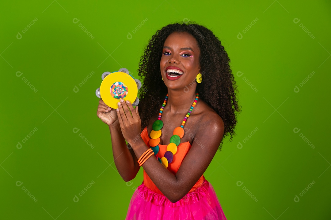 Linda morena sorridente fantasiada para carnaval segurando pandeiro sobre fundo verde isolado