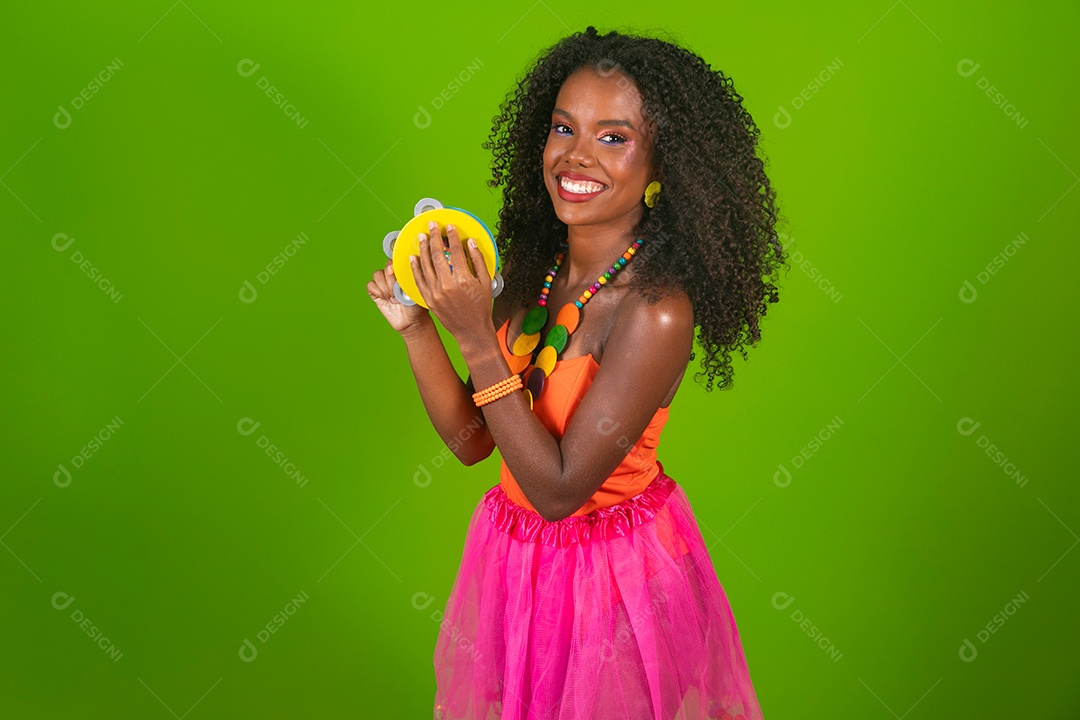 Linda morena sorridente fantasiada segurando pandeiro sobre fundo verde isolado