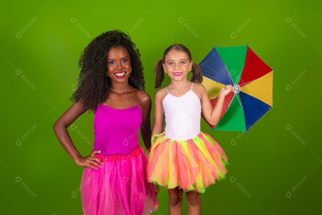 Lindas morena ao lado de sua filha fantasiada segurando guarda-chuva sobre fundo verde isolado