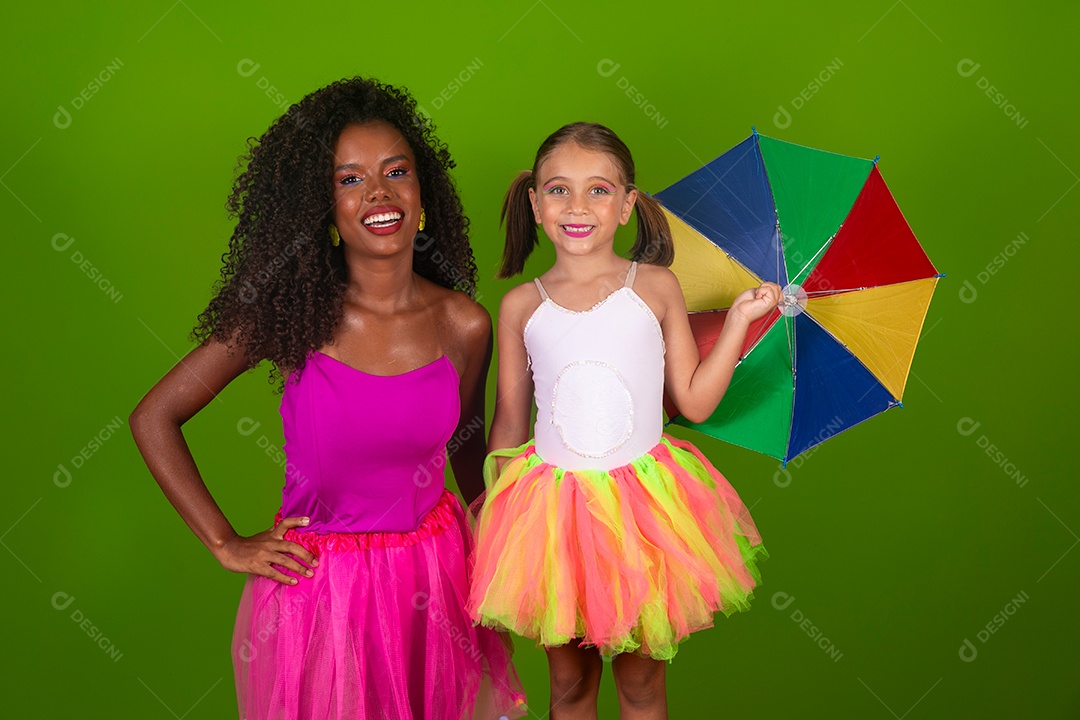Lindas morena ao lado de sua filha fantasiada segurando guarda-chuva sobre fundo verde isolado