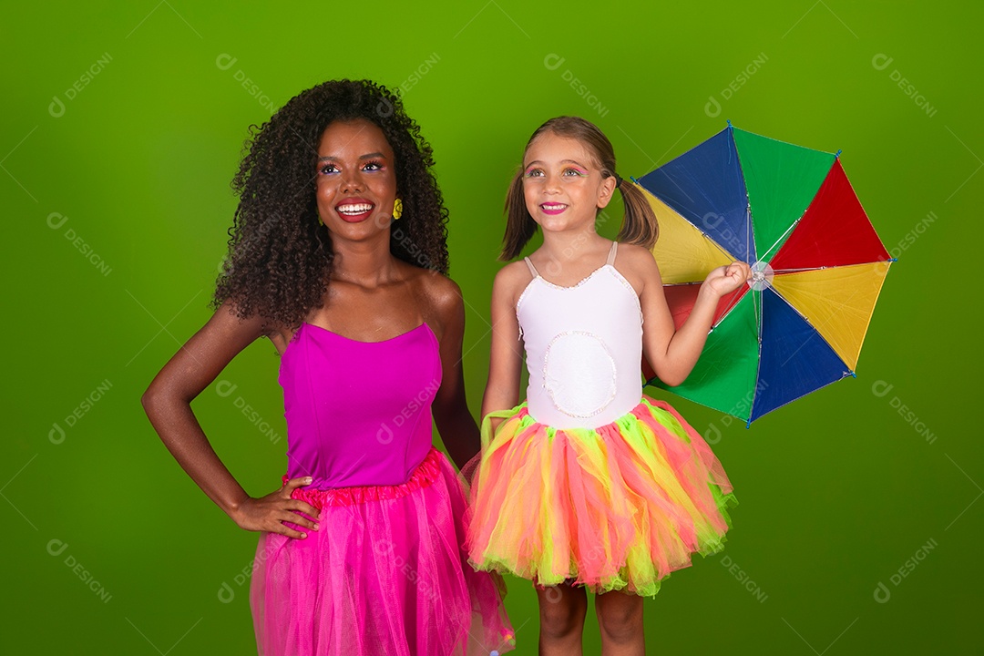 Lindas morena ao lado de sua filha fantasiada segurando guarda-chuva sobre fundo verde isolado